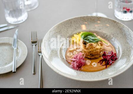 Hecht-Cutlet mit Kürbissauce und fermentierten Kohl in verschiedenen Farben in einem Restaurant Stockfoto