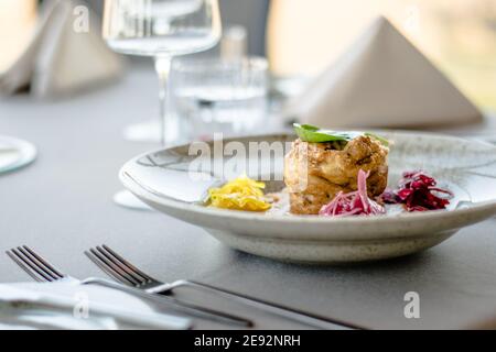 Hecht-Cutlet mit Kürbissauce und fermentierten Kohl in verschiedenen Farben in einem Restaurant Stockfoto