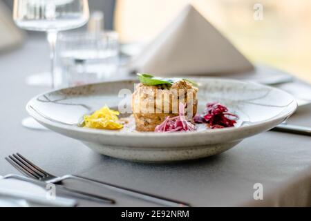Hecht-Cutlet mit Kürbissauce und fermentierten Kohl in verschiedenen Farben in einem Restaurant Stockfoto