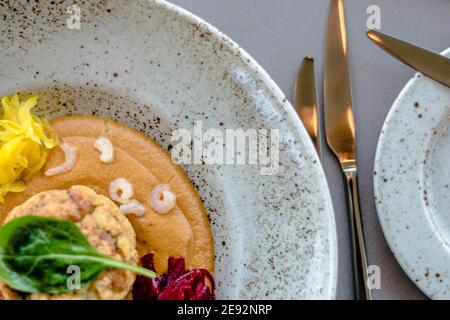 Hecht-Cutlet mit Kürbissauce und fermentierten Kohl in verschiedenen Farben in einem Restaurant Stockfoto