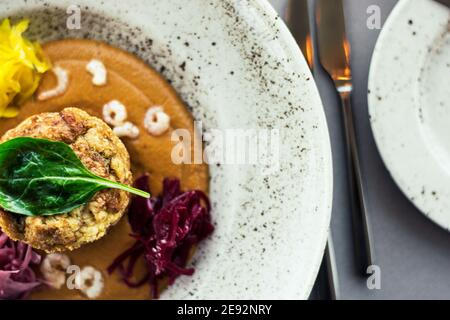 Hecht-Cutlet mit Kürbissauce und fermentierten Kohl in verschiedenen Farben in einem Restaurant Stockfoto