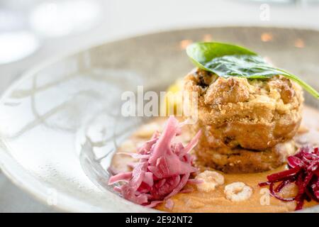 Hecht-Cutlet mit Kürbissauce und fermentierten Kohl in verschiedenen Farben in einem Restaurant Stockfoto