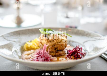 Hecht-Cutlet mit Kürbissauce und fermentierten Kohl in verschiedenen Farben in einem Restaurant Stockfoto