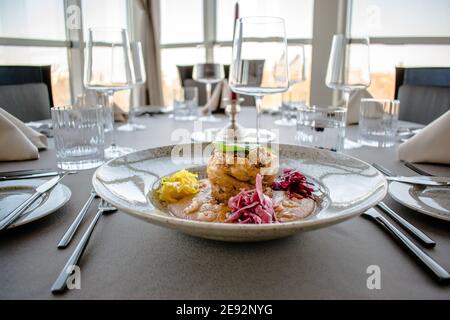 Hecht-Cutlet mit Kürbissauce und fermentierten Kohl in verschiedenen Farben in einem Restaurant Stockfoto