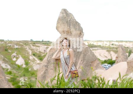 Mädchen steht in Kappadokien, alte Höhlenstadt im Hintergrund, Türkei. Stockfoto