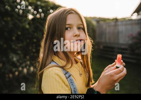 Pre-pubertär Mädchen weg beim Essen Wassermelone im Hinterhof Stockfoto