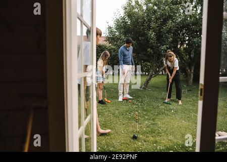 Eltern spielen Polo mit Kindern im Hinterhof Stockfoto