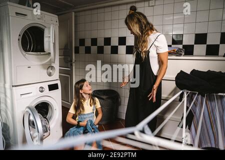 Mutter und Tochter machen Wäsche im Hauswirtschaftsraum Stockfoto