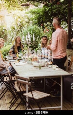 Vater im Gespräch mit der Familie während der gesellschaftlichen Zusammenkunft in Dinner-Party Stockfoto