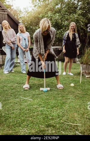 Großmutter spielt Polo mit Familie im Hinterhof Stockfoto