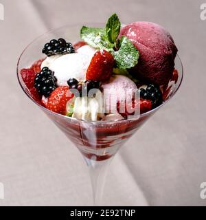 Eis servieren in einem Glas mit verschiedenen Beeren Stockfoto