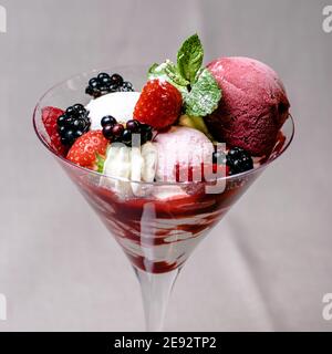 Eis servieren in einem Glas mit verschiedenen Beeren Stockfoto