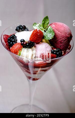 Eis servieren in einem Glas mit verschiedenen Beeren Stockfoto