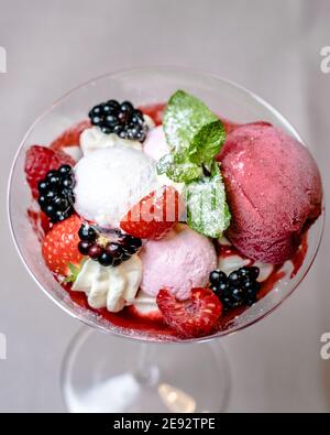 Eis servieren in einem Glas mit verschiedenen Beeren Stockfoto