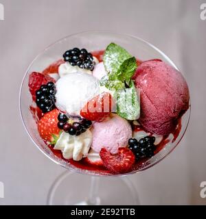 Eis servieren in einem Glas mit verschiedenen Beeren Stockfoto