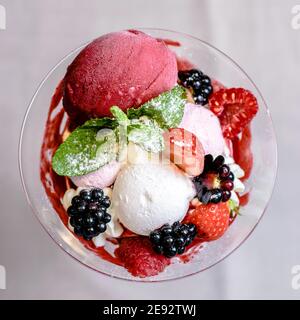 Eis servieren in einem Glas mit verschiedenen Beeren Stockfoto