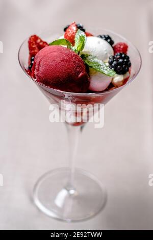 Eis servieren in einem Glas mit verschiedenen Beeren Stockfoto