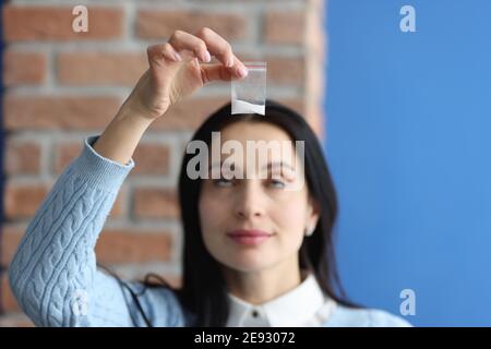 Frau, die ein Päckchen mit weißem Narkosepulver in der Nähe hält Stockfoto