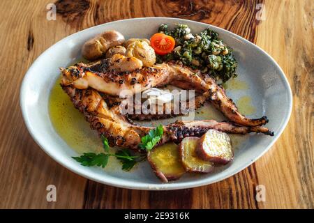 Beliebte portugiesische gegrillte Krake Platte mit Süßkartoffeln und etwas grünem Gemüse. Stockfoto