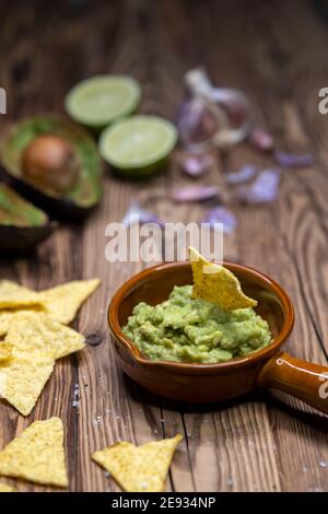 Avocado Dip mit Knoblauch, Chili, Pfeffer und Limettensaft mit Mais Nachos gewürzt Stockfoto