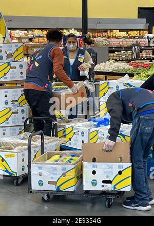 FRESNO, VEREINIGTE STAATEN - Jan 30, 2021: Ein Foto von Inside Walmart, wo Mitarbeiter Bananas aus Boxen auspacken Stockfoto