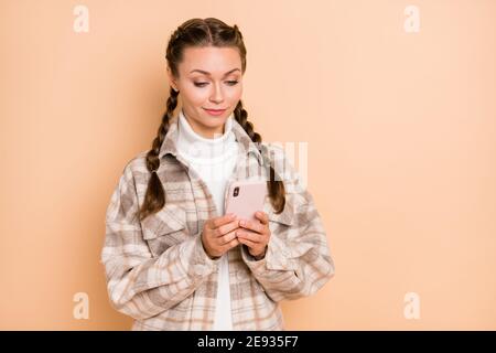 Foto von jungen attraktiven schönen glücklich positiv lächelnd Mädchen blogger Verwenden Sie Smartphone isoliert auf beigefarbenem Hintergrund Stockfoto