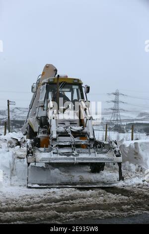 Littleborough, Großbritannien. Februar 2021. Der Schneefall hat viele Nebenstraßen im Littleborough-Gebiet blockiert. Ein Traktorfahrer kam zur Rettung des Personals, das versuchte, ein Tierschutzgebiet zu erreichen, das von karitativen Tieren in Not geführt wird. Blackstone Edge, Littleborough, Lancashire, Großbritannien. Kredit: Barbara Cook/Alamy Live Nachrichten Stockfoto