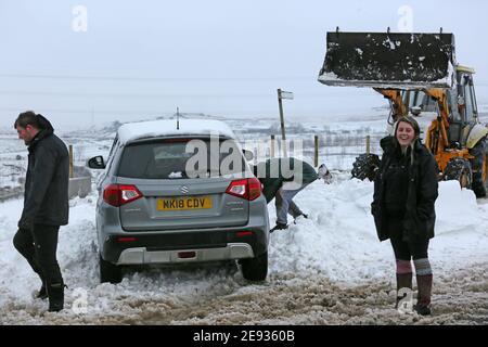 Littleborough, Großbritannien. Februar 2021. Der Schneefall hat viele Nebenstraßen im Littleborough-Gebiet blockiert. Ein Traktorfahrer kam zur Rettung des Personals, das versuchte, ein Tierschutzgebiet zu erreichen, das von karitativen Tieren in Not geführt wird. Blackstone Edge, Littleborough, Lancashire, Großbritannien. Kredit: Barbara Cook/Alamy Live Nachrichten Stockfoto