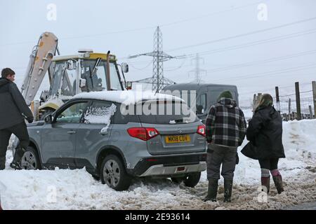 Littleborough, Großbritannien. Februar 2021. Der Schneefall hat viele Nebenstraßen im Littleborough-Gebiet blockiert. Ein Traktorfahrer kam zur Rettung des Personals, das versuchte, ein Tierschutzgebiet zu erreichen, das von karitativen Tieren in Not geführt wird. Blackstone Edge, Littleborough, Lancashire, Großbritannien. Kredit: Barbara Cook/Alamy Live Nachrichten Stockfoto