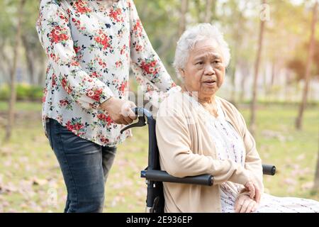 Asiatische ältere oder ältere alte Dame Frau lächeln helles Gesicht Patient auf Rollstuhl im Park. Stockfoto