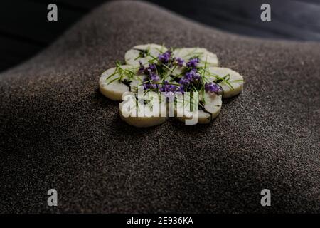 Fischroulade auf einem interessanten Teller, der mit Tannennadeln verziert ist In einem Restaurant Stockfoto