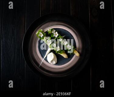 Gericht gekochten weißen Spargel plattiert und mit Weiß dekoriert Blumen und Sahne auf der Seite in einem Restaurant Stockfoto