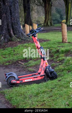 Ein E-Scooter parkte am Rande des Abington Park auf dem Bürgersteig entlang der Park Avenue South an einem feuchten Morgen, Northampton, England, Großbritannien. Stockfoto