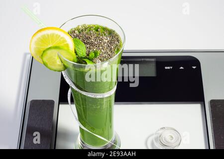 Gesunde Ernährung trinken, ein Glas Diät trinken auf der Skala, Gewicht zu verlieren, grün Smoothie mit Inhalt Stockfoto