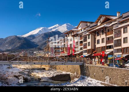 Bansko, Bulgarien - 28. Januar 2021: Fluss Glazne in der bulgarischen Stadt, Hotelhäuser und Schnee Pirin Berge Stockfoto