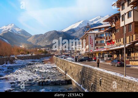 Bansko, Bulgarien - 28. Januar 2021: Fluss Glazne in der bulgarischen Stadt, Hotelhäuser und Schnee Pirin Berge Stockfoto