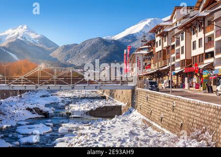 Bansko, Bulgarien - 28. Januar 2021: Fluss Glazne in der bulgarischen Stadt, Hotelhäuser und Schnee Pirin Berge Stockfoto