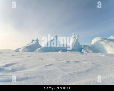 Eisberg gefroren in das Meereis der Melville Bay, Teil der Baffin Bay, in der Nähe von Kullorsuaq im hohen Norden von Westgrönland. Stockfoto