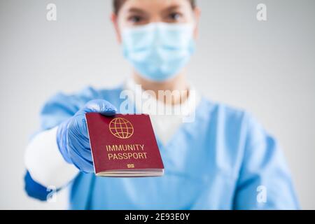 UK NHS Arzt mit roten globalen Immunität Pass, SARS Re-Infektion risikofrei Zertifikat Konzept, erholt COVID-19 Patienten erhalten Nachweis der Genesung Stockfoto