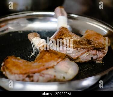 Koch bereitet Wachteln in einer Pfanne in einem Restaurant zu Stockfoto