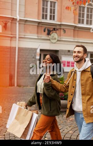 Junge Paare, die mit Einkaufstüten Stockfoto