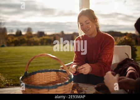 Frau putzt Pilze auf der Veranda Stockfoto