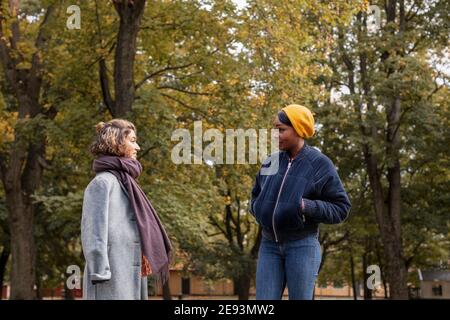 Zwei junge Frauen sprechen in Park Stockfoto
