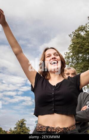 Glückliches Teenager-Mädchen mit erhobenen Armen Stockfoto
