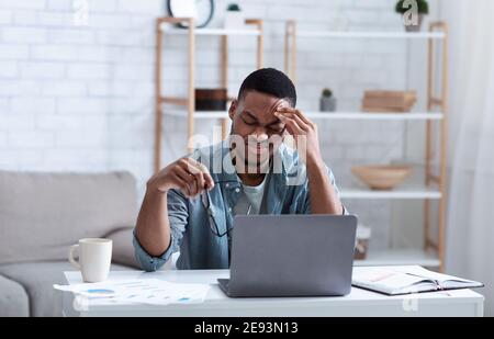 Black Business Man Mit Kopfschmerzen Berühren Kopf Sitzen Am Arbeitsplatz Stockfoto