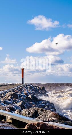 Raues Wetter neben dem Steg und einem Leuchtturm Stockfoto