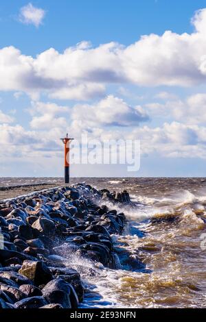 Raues Wetter neben dem Steg und einem Leuchtturm Stockfoto