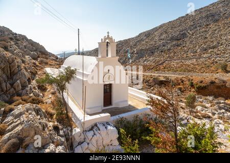 Folegandros Insel, Griechenland - 25 September 2020: Traditionelle weiße Kapelle Agioi Anargyroi zwischen den Felsen. Stockfoto