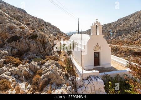 Folegandros Insel, Griechenland - 25 September 2020: Traditionelle weiße Kapelle Agioi Anargyroi zwischen den Felsen. Stockfoto