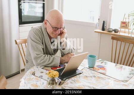 Mann, der am Tisch sitzt und Video-Chat auf dem Tablet hat Stockfoto